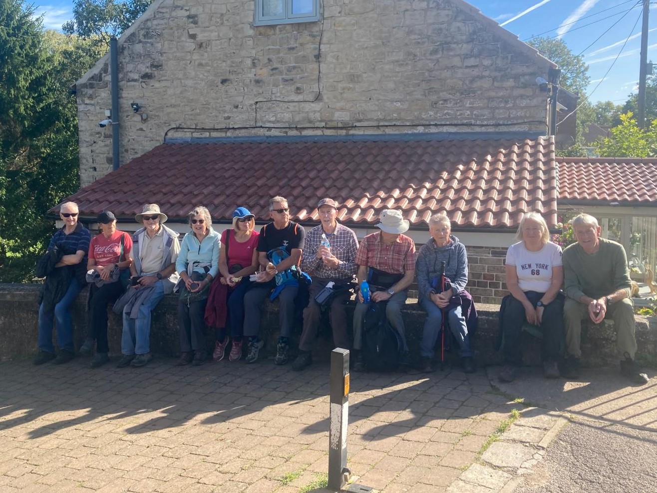 the u3a walking group sitting on a wall at Turnerwood
